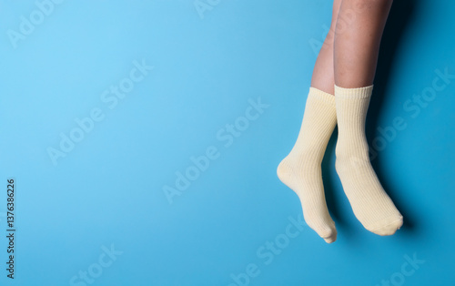 Child wearing socks over blue color background