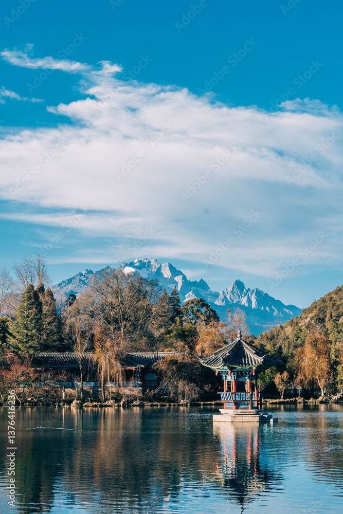Fototapeta premium Photograph of Black Dragon Pool with Jade Dragon Snow Mountain and bridge in Lijiang