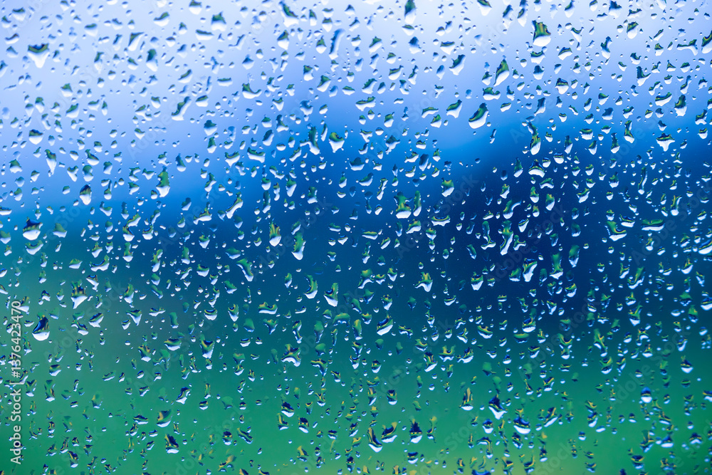 Photograph of raindrops on a glass surface reflecting and distorting a vibrant and colourful background capturing the beauty of light and water and sunlight. Photograph of raindrops on a glass surface reflecting and distorting a vibrant and colourful background capturing the beauty of light and water and sunlight.