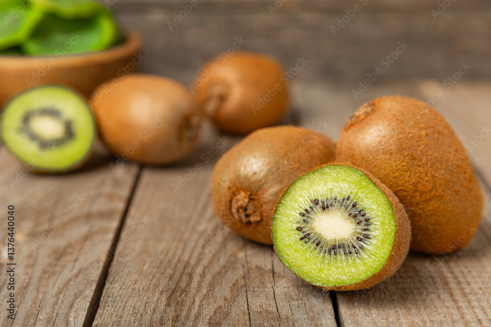 Kiwi on wooden background. Whole fruit and slices pieces of green kiwi on table. fresh ripe juicy kiwi. Tropical fruit. Organic fruit. Healthy eating. Space for text. Copy space