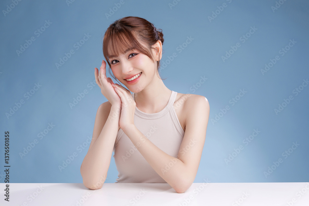 Beautiful young Asian woman model with bangs and natural makeup on face clean fresh skin on isolated blue background. Cute girl portrait, Facial treatment, Body care, Beauty and Spa. Beautiful young Asian woman model with bangs and natural makeup on face clean fresh skin on isolated blue background. Cute girl portrait, Facial treatment, Body care, Beauty and Spa.