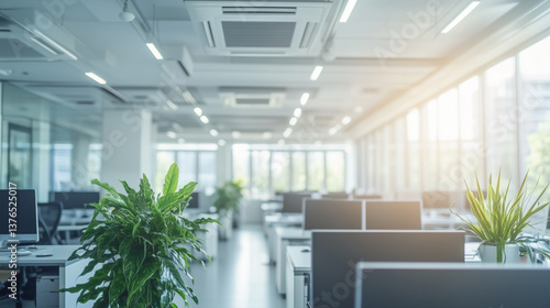 Modern open office with desks, plants, and ceiling air conditioning