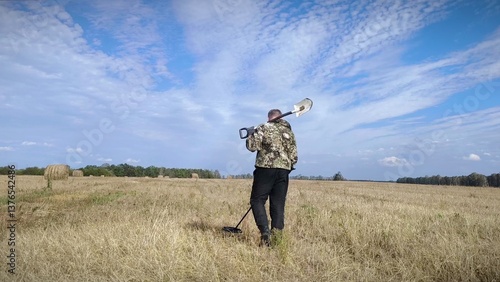 Canvastavla man in a field with a metal detector