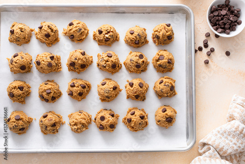 Valokuva Chocolate chip cookies with pecan nuts, cookie dough ready on a baking sheet