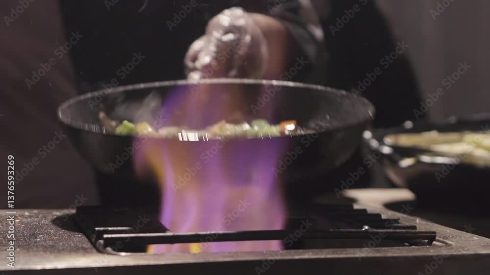 Tossing vegetables in pan. Food on fire. Tossing vegetables in pan. Food on fire.