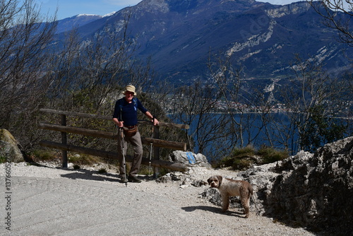 Obraz na płótnie Mann und sein Lagotto Romagnolo Hund wandern oberhalb vom Gardasee w salonie