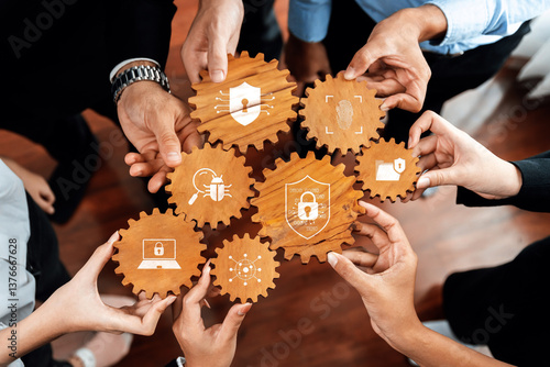 A group of diverse individuals holding wooden gears with security symbols, illustrating teamwork in cybersecurity, protection, and digital safety solutions for modern challenges. Amity