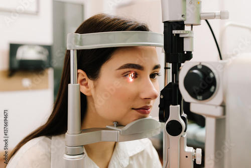 Girl is visiting ophthalmologist for eye examination. Ophthalmology procedure with slit lamp for eyes and cornea checkup.