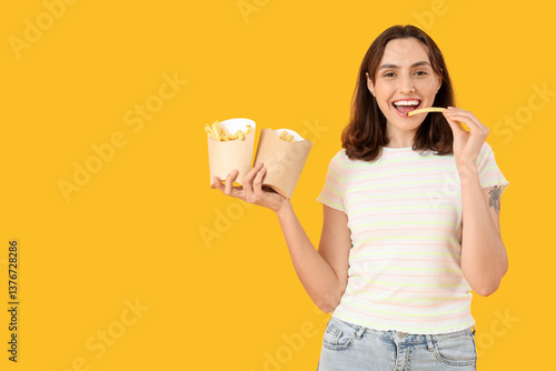 Young woman eating french f...