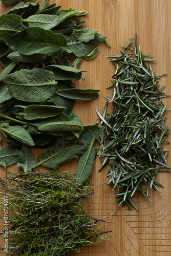  Fresh herbs on wooden background, sage, rosemary and thyme leaves, healthy kitchen / nutrition concept., close-up, top view.