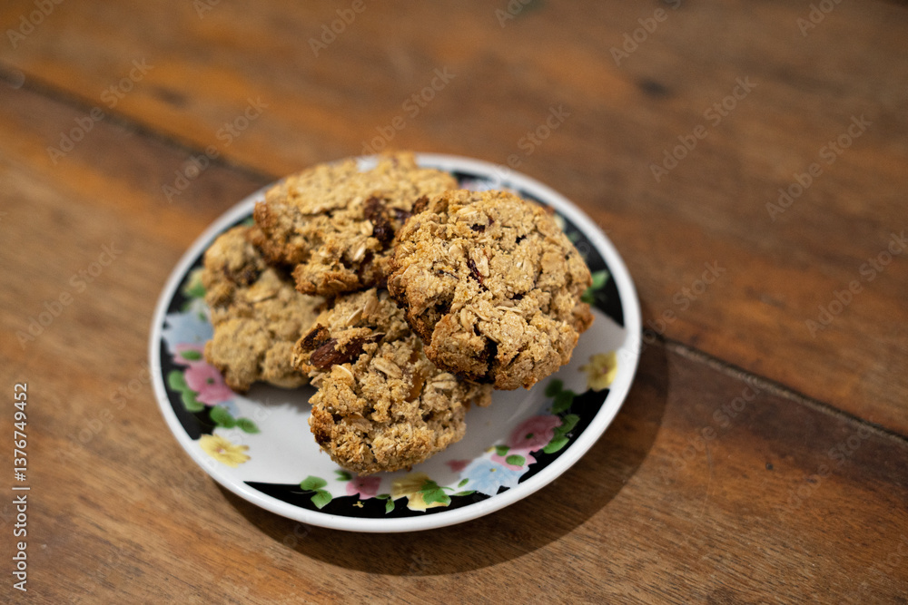 cookies, oatmeal cookies resting over a little dish plate, on a wooden table cookies, oatmeal cookies resting over a little dish plate, on a wooden table