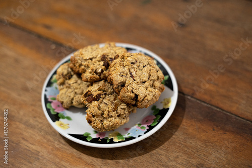 cookies, oatmeal cookies resting over a little dish plate, on a wooden table