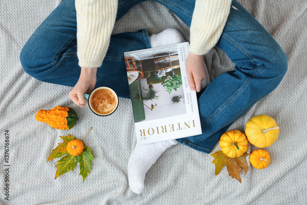Φωτογραφία Young woman with cup of pumpkin coffee, magazine and autumn leaves sitting on be