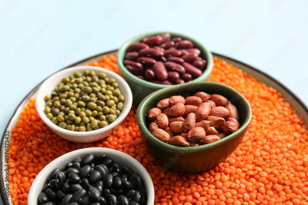 Bowls with raw legumes on color background, closeup Bowls with raw legumes on color background, closeup