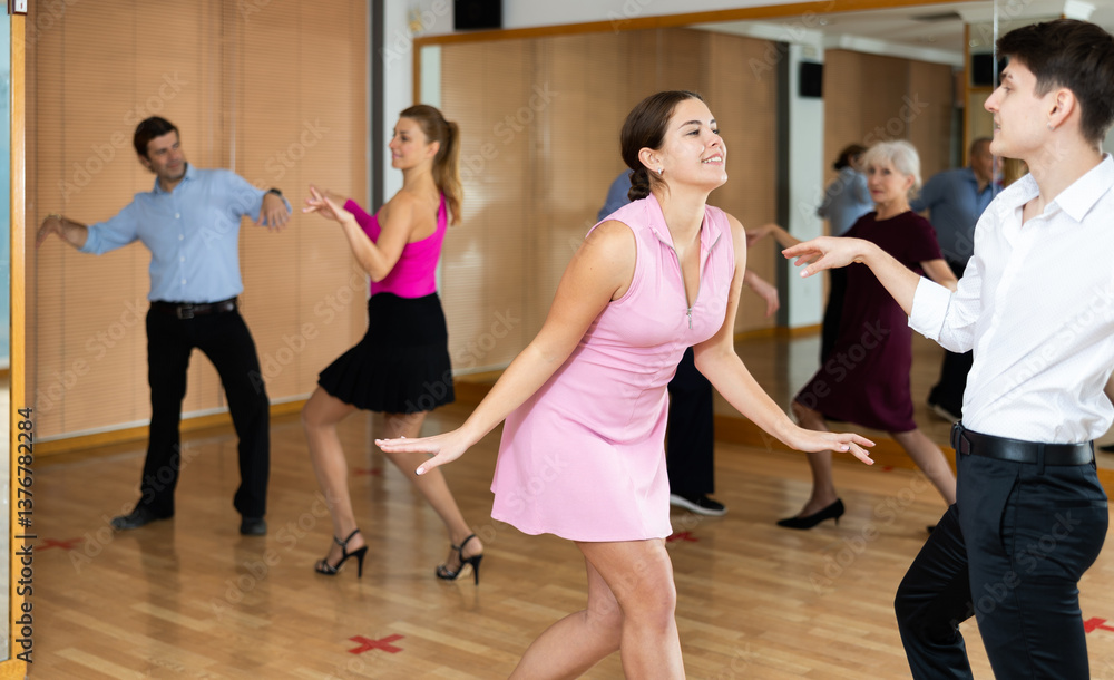 Obraz premium Dynamic young pair engaging in Latino dance in dance studio. Pairs training ballroom dance in hall