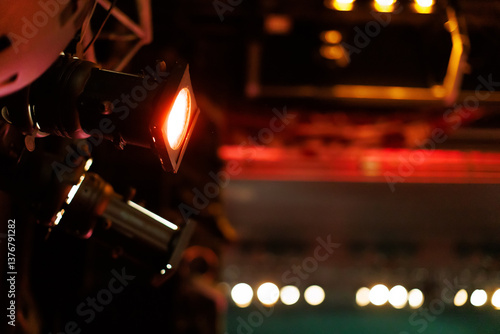 Lighting equipment illuminates a performance stage during an evening event in a vibrant theater setting