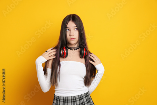 Teenage girl wearing stylish clothes and accessories on orange background. Makeup in anime style