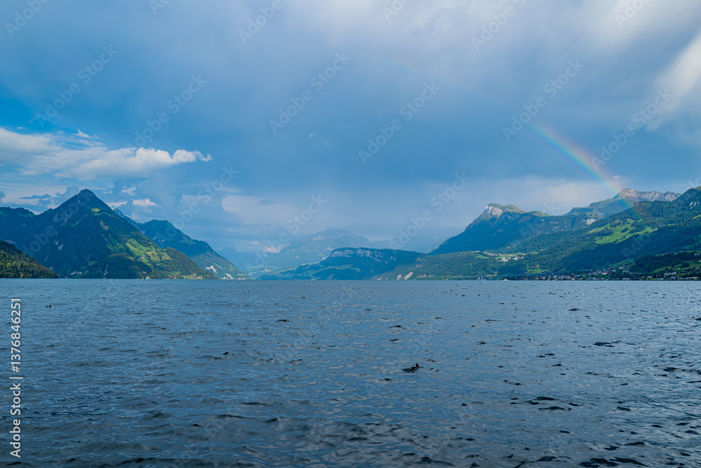 Fototapeta premium Mountain background. Alps mountain on sunny day. Mountain under clouds in blue sky. Blue nature background. Blue lake with blue sky near mountain.