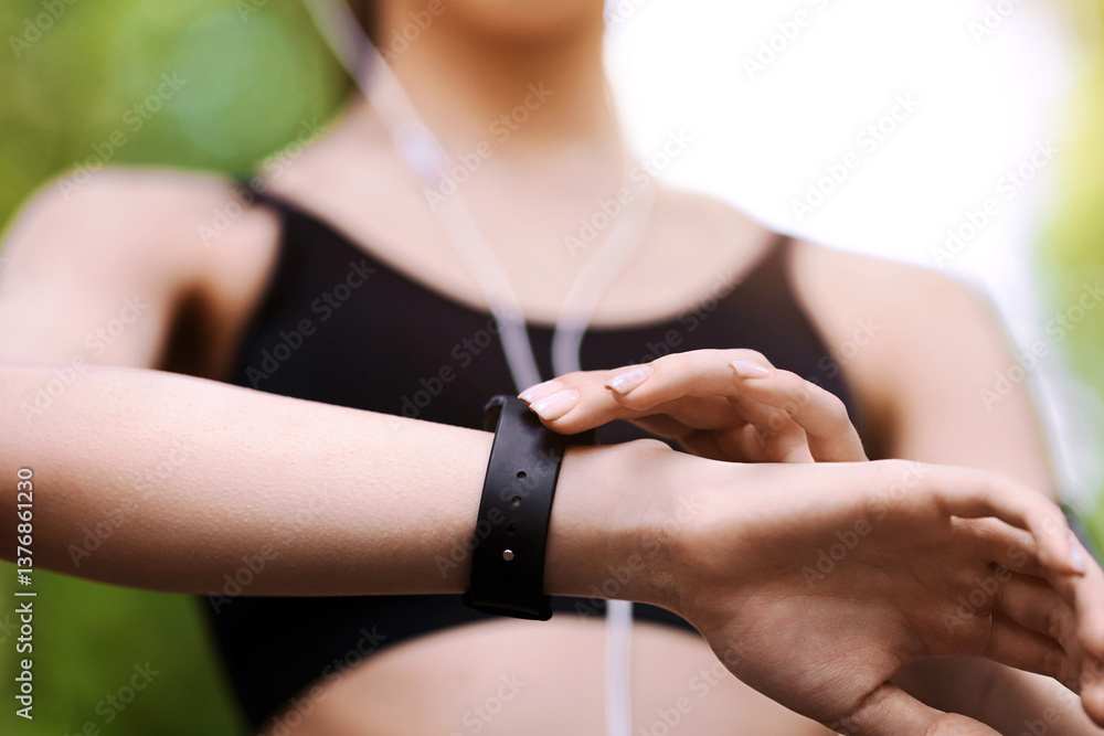 Fototapeta premium Gadgets For Sport. Female athlete using smartwatch outdoors to track her training progress, closeup image with selective focus