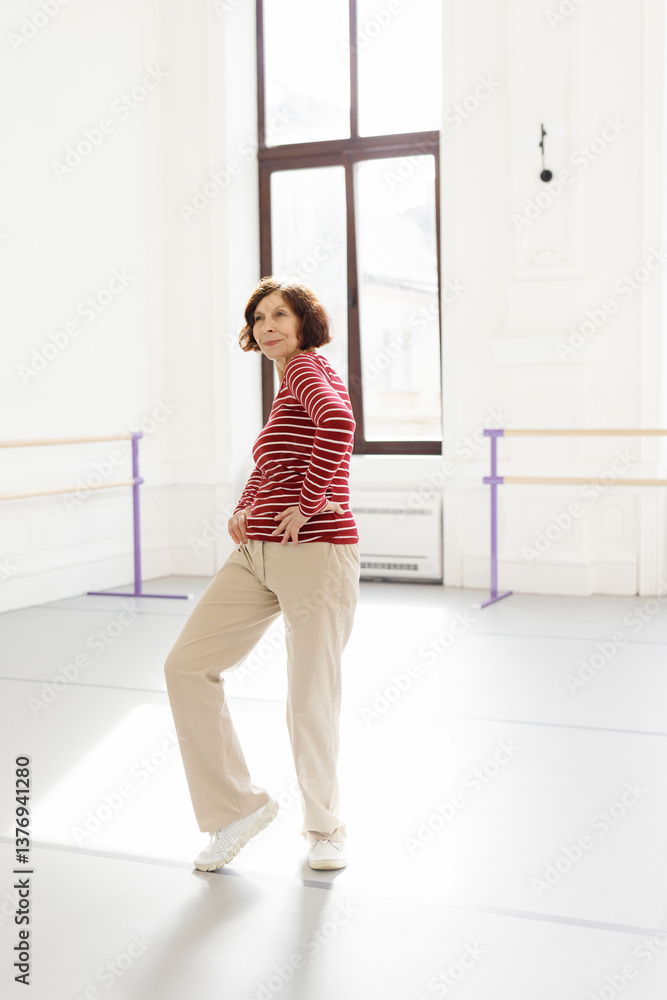 Smiling elderly woman in casual clothes dancing at dance school Smiling elderly woman in casual clothes dancing at dance school