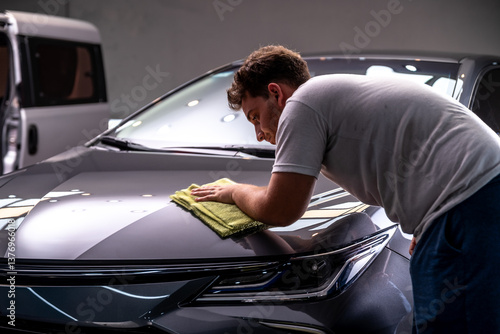 car detailing frotando paño de microfibra con cera el automovil 