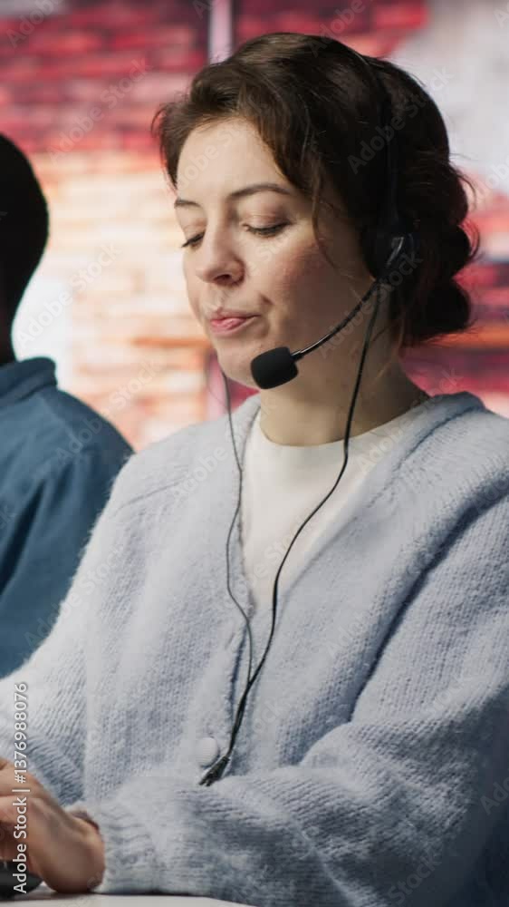 Vertical video Teamworking call center coworkers in office helping customers by answering questions. Team of agents in customer support workplace in front of PC using headset mic to talk with clients Vertical video Teamworking call center coworkers in office helping customers by answering questions. Team of agents in customer support workplace in front of PC using headset mic to talk with clients