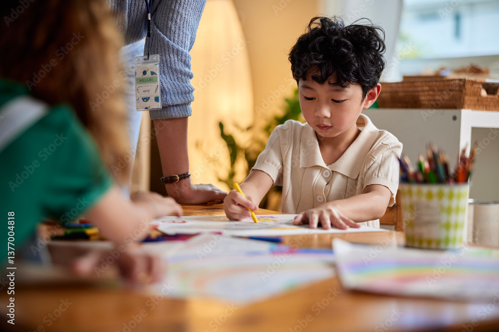 Cute boy coloring with crayons in art class Cute boy coloring with crayons in art class