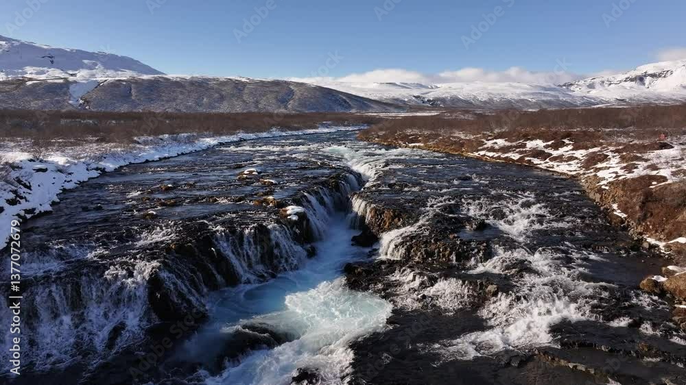 Brúarfoss waterfall in Iceland cascades over rugged volcanic rock, creating mesmerizing turquoise waters framed by a winter landscape. Brúarfoss waterfall in Iceland cascades over rugged volcanic rock, creating mesmerizing turquoise waters framed by a winter landscape.