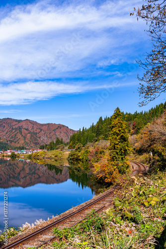 Fukushima, JAPAN - Nov 10, 2024: Tadami Line train tracts run along Tadami Riverside in autumn at Aizu-Kawaguchi, Mishima, Fukushima