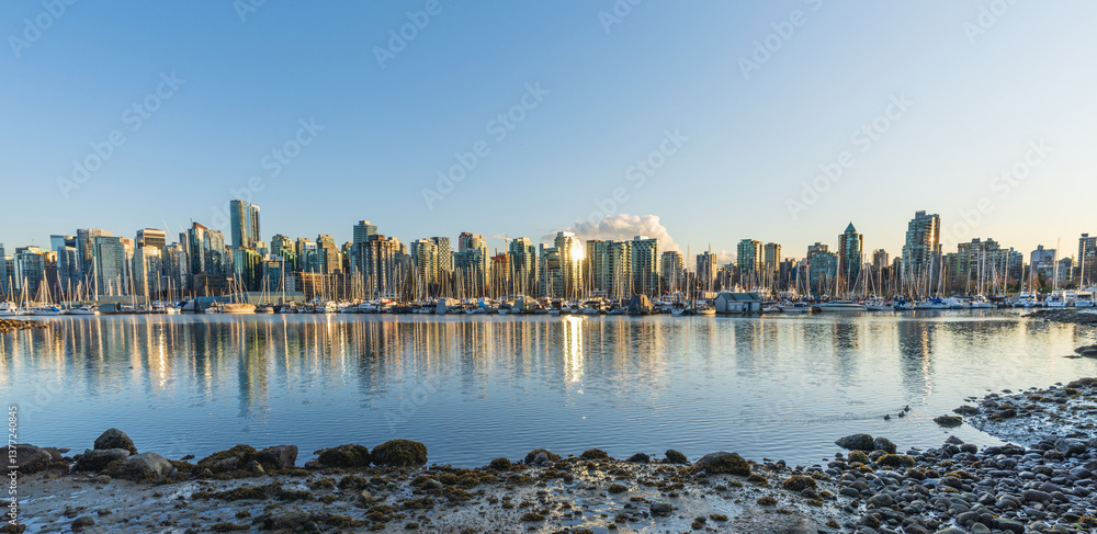 Obraz premium Vancouver downtown skyline panoramic view at sunset time. Skyscrapers reflection on the Vancouver Harbour. British Columbia, Canada.