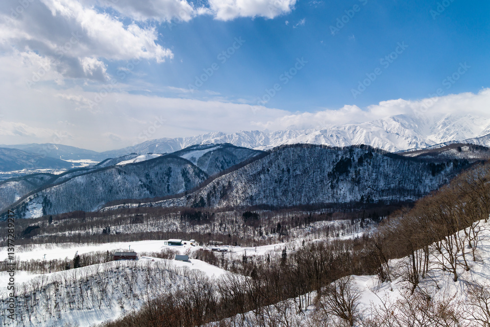 Snow covered mountain and forest alpine scenery on a sunny day. Hakuba, Nagano