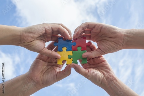 Wallpaper Mural Hands of diverse people connecting colorful puzzle pieces against blue sky. Torontodigital.ca