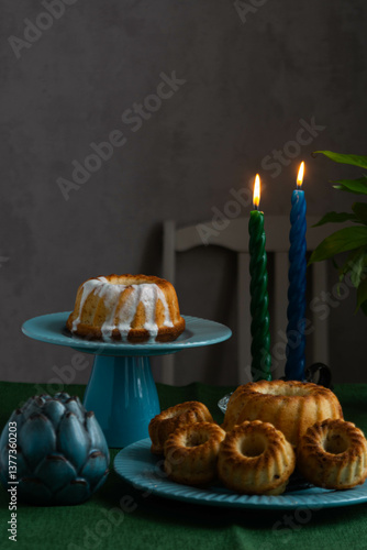 Easter cake on a green stand against the background of burning candles.