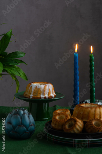 Easter cake on a green stand against the background of burning candles.