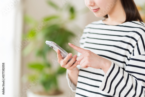 スマホを操作する若い女性。