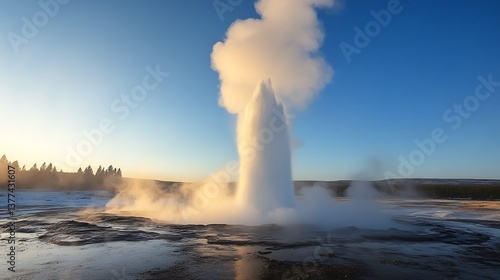 Wallpaper Mural A dramatic shot of a geyser erupting high into the air, steam rising against the backdrop of a clear blue sky Torontodigital.ca