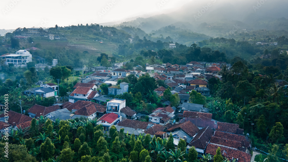 Fototapeta premium An atmospheric aerial image showing a vibrant village surrounded by tropical vegetation and forest, with red-tiled roofs and tight-knit houses