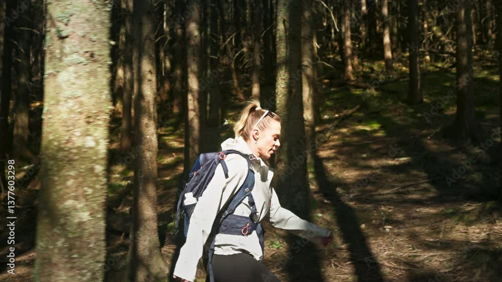 Sporty adult woman hiking through a forest. Slow motion Sporty adult woman hiking through a forest. Slow motion