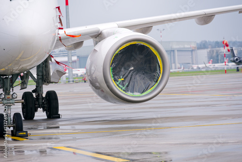 Close-up of covered jet engine of parked Swiss passenger airplane at Swiss Airport Zürich Kloten on a rainy spring day. Photo taken March 29th, 2025, Zurich Kloten, Switzerland.