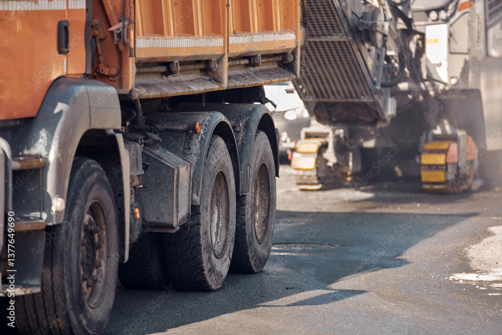 Heavy construction machines and truck outdoors for public street reconstruction.