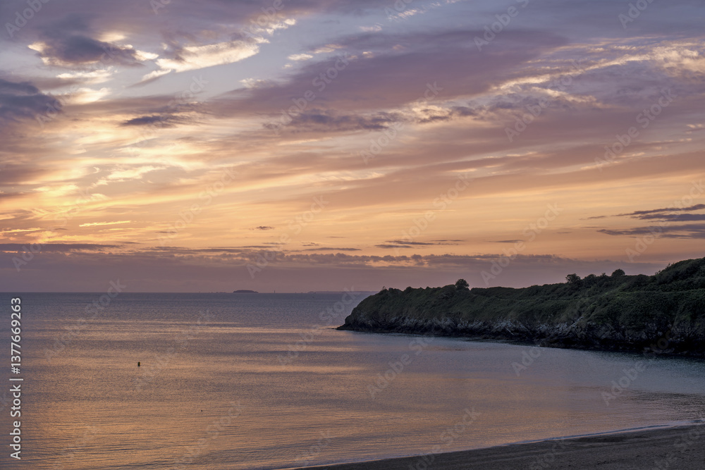 View of the sandy beach at low tide and sunset of Saint-Cast-Le-Guildo in summer in Côtes d'Armor, Brittany, France View of the sandy beach at low tide and sunset of Saint-Cast-Le-Guildo in summer in Côtes d'Armor, Brittany, France