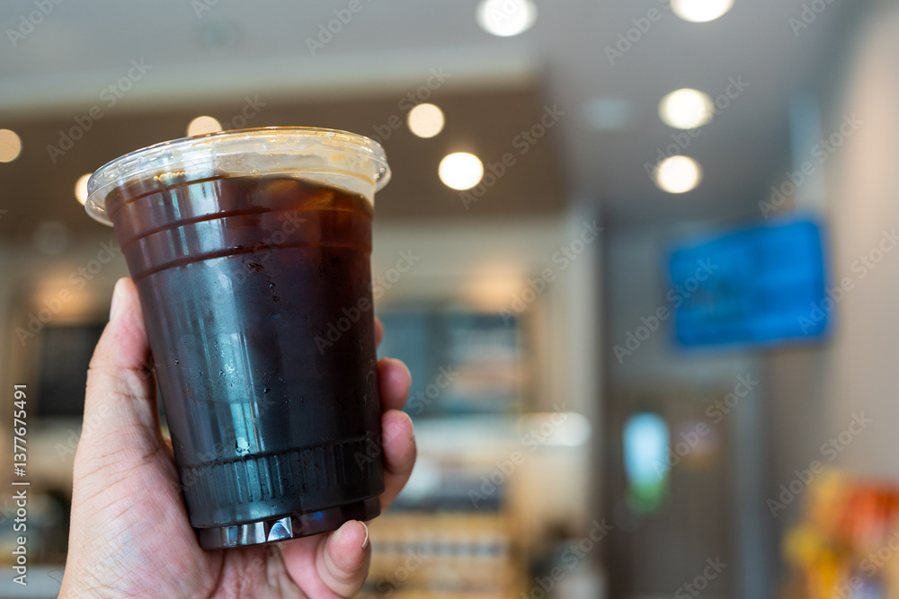 Takeaway a cup of iced black coffee on hand at coffee shop Takeaway a cup of iced black coffee on hand at coffee shop