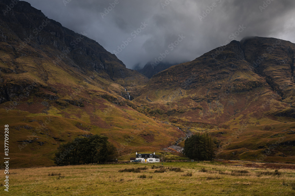 Dramatic peaks and misty valleys define Glen Coe, Scotland’s iconic Highland landscape. Golden light dances on rugged slopes, creating a scene of wild, untamed beauty.