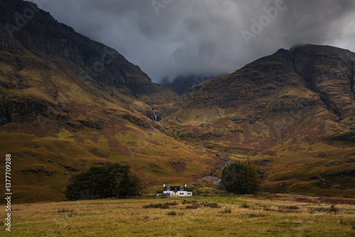 Obraz na płótnie Dramatic peaks and misty valleys define Glen Coe, Scotland’s iconic Highland landscape. Golden light dances on rugged slopes, creating a scene of wild, untamed beauty. w salonie