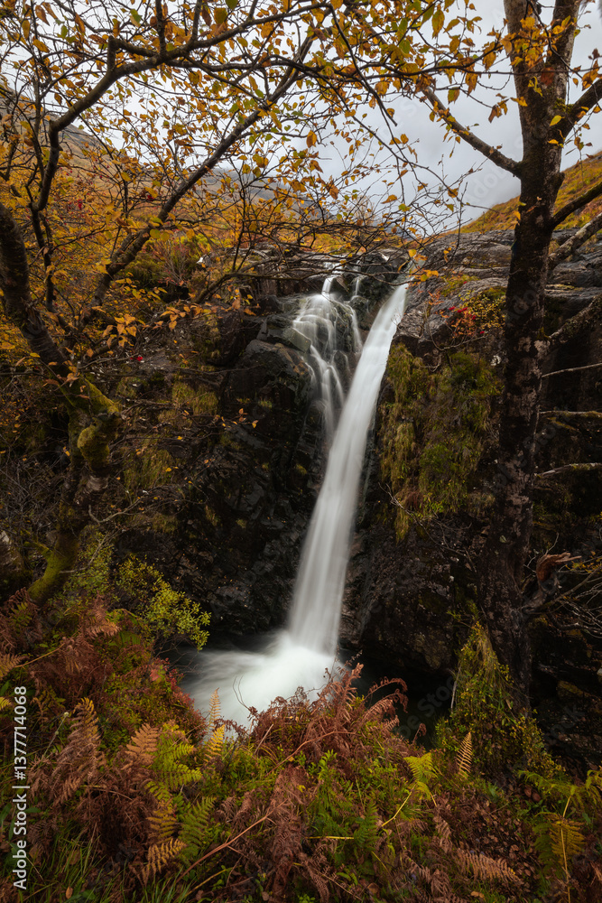 Dramatic peaks and misty valleys define Glen Coe, Scotland’s iconic Highland landscape. Golden light dances on rugged slopes, creating a scene of wild, untamed beauty.