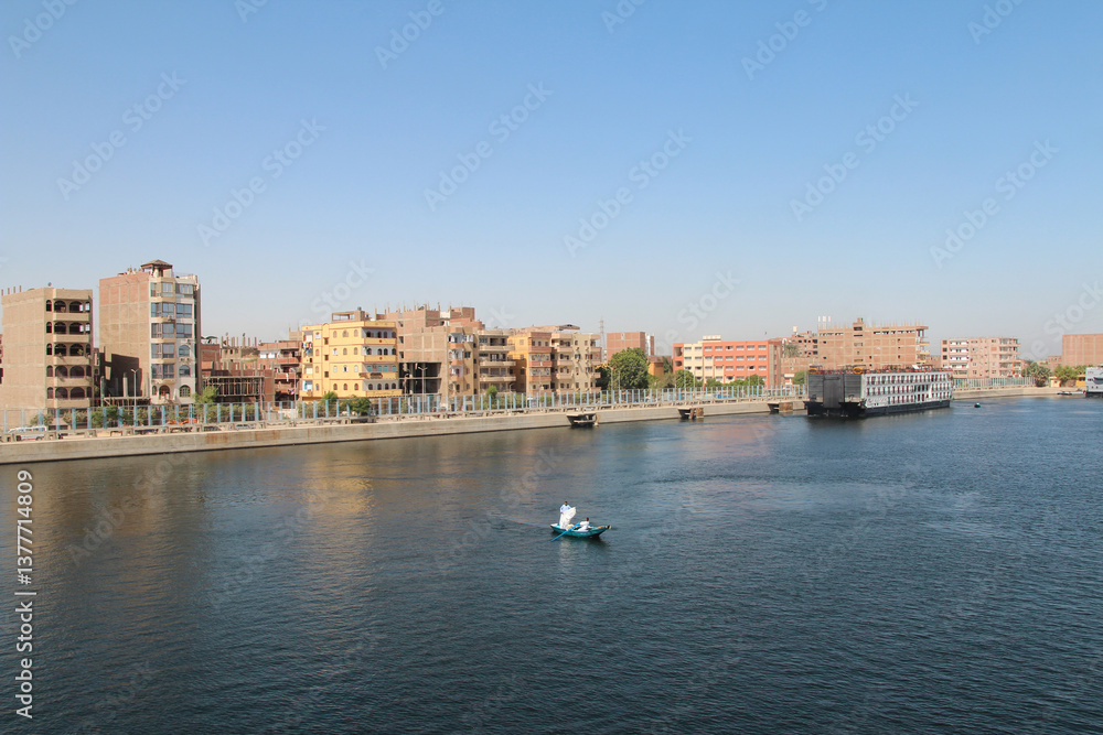 Fototapeta premium View of Esna city with vendors in their rowing boat near the Esna Lock on the River Nile, Egypt