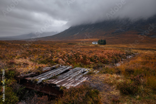 Obraz na płótnie Dramatic peaks and misty valleys define Glen Coe, Scotland’s iconic Highland landscape. Golden light dances on rugged slopes, creating a scene of wild, untamed beauty. w salonie