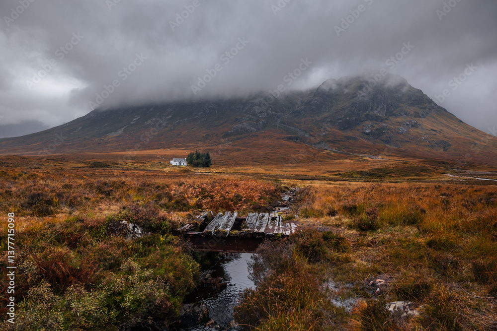 Dramatic peaks and misty valleys define Glen Coe, Scotland’s iconic Highland landscape. Golden light dances on rugged slopes, creating a scene of wild, untamed beauty.