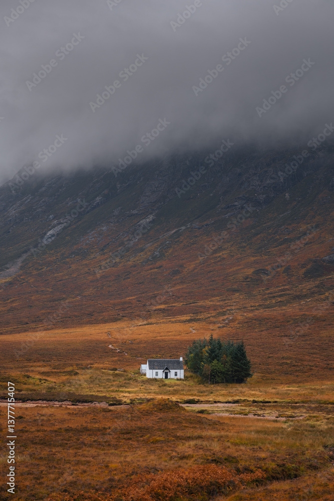 Dramatic peaks and misty valleys define Glen Coe, Scotland’s iconic Highland landscape. Golden light dances on rugged slopes, creating a scene of wild, untamed beauty.
