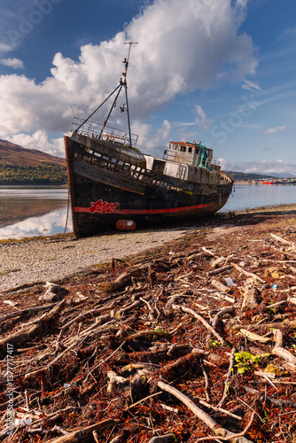 Obraz na płótnie Golden light bathes Corpach’s shores, where the iconic shipwreck rests against Ben Nevis’ misty peaks. A serene autumn morning unfolds over Scotland’s rugged beauty. w salonie